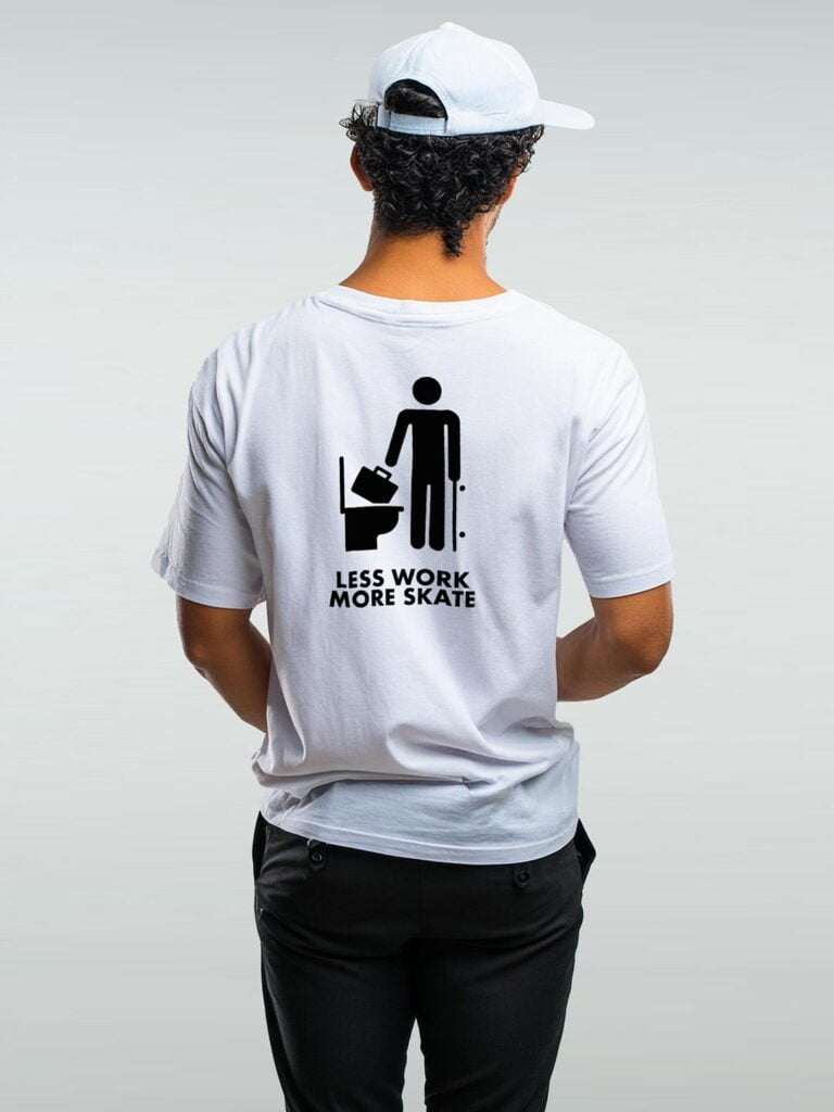 Camiseta blanca con un ícono de un tipo lanzando un maletín al WC y 'Less Work More Skate' en letras grandes. ¡Camisetas de skate únicas!