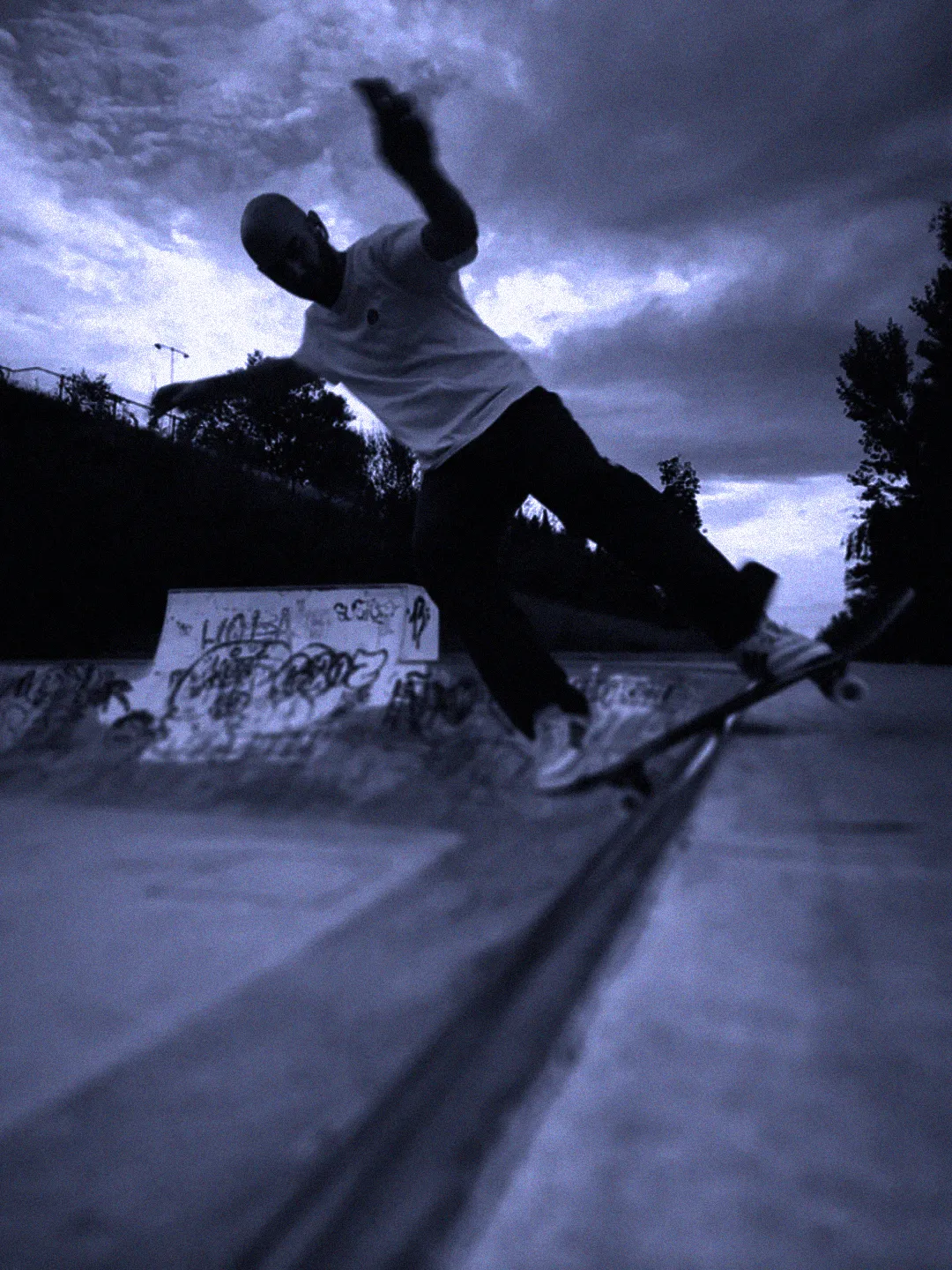 Skateboarding night session in Torrelodones, Madrid at La Kantorre — skater doing a no comply on the mini ramp, Nosebonk crew.